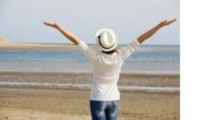 woman on the beach with her hands in the air