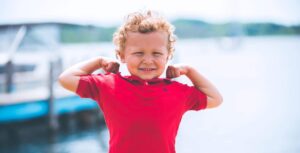child flexing arm muscles