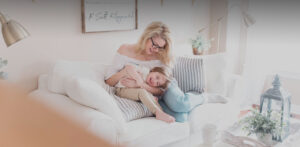 woman playing with child on couch