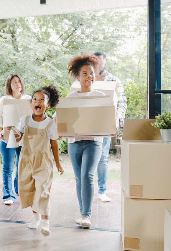 Family walking into a new home unpacking boxes after a move