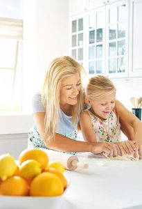 Happy mother and daughter in organized, clam kitchen