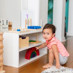 Toddler playing in clean organized playroom