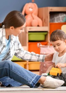 Mother playing with boy in organized playroom