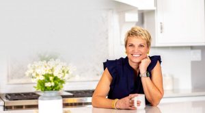 Susan Stewart of Perfectly Placed Organization & Design sitting at clean, organized kitchen counter