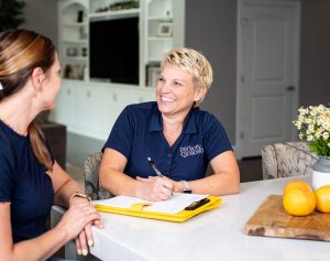 Expert home organizer Susan Stewart talking with client at the kitchen counter